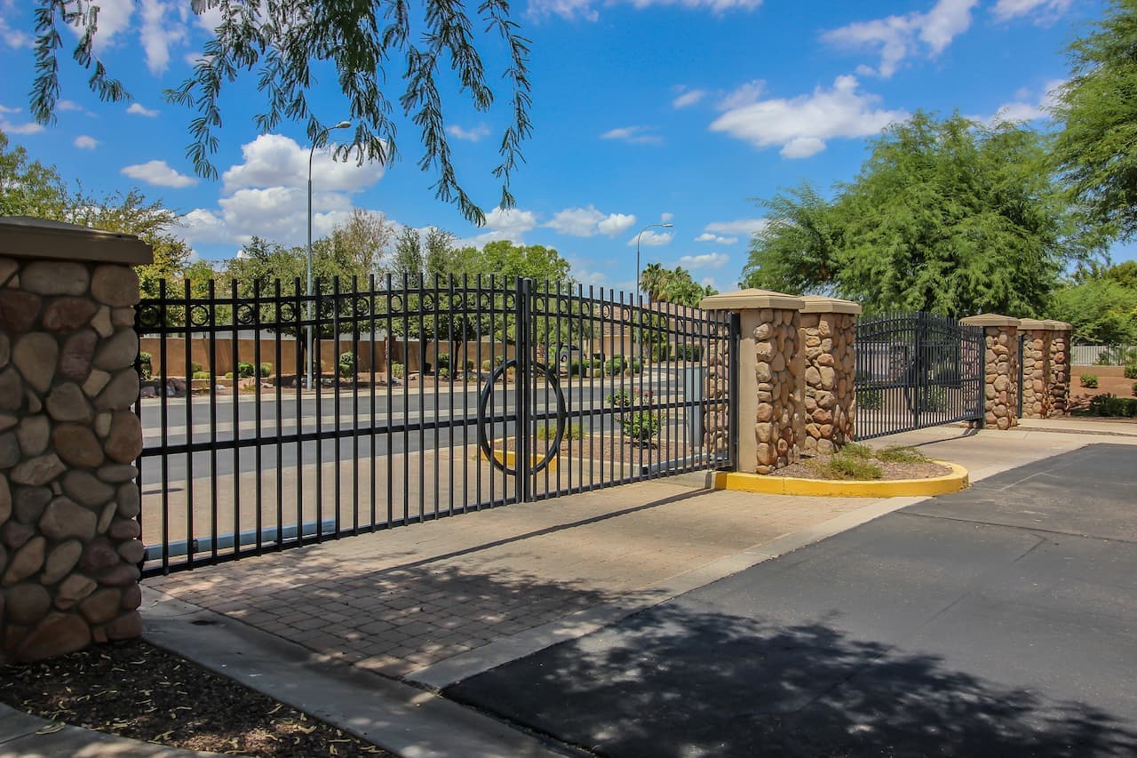 Contemporary vertical wooden slat driveway gate with white stucco pillars installed in Bay Area by Automatic Gate Mates