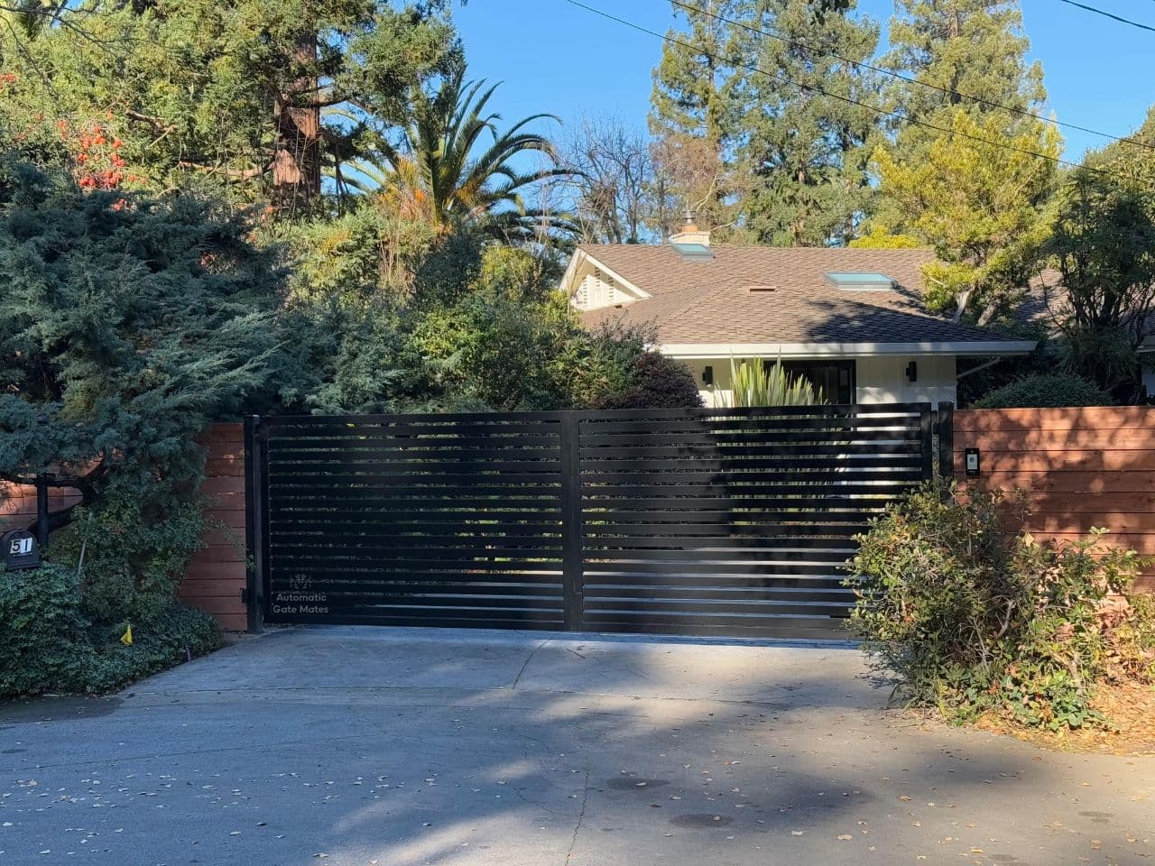 Wrought iron commercial entrance gate with decorative stone columns installed in Bay Area by Automatic Gate Mates